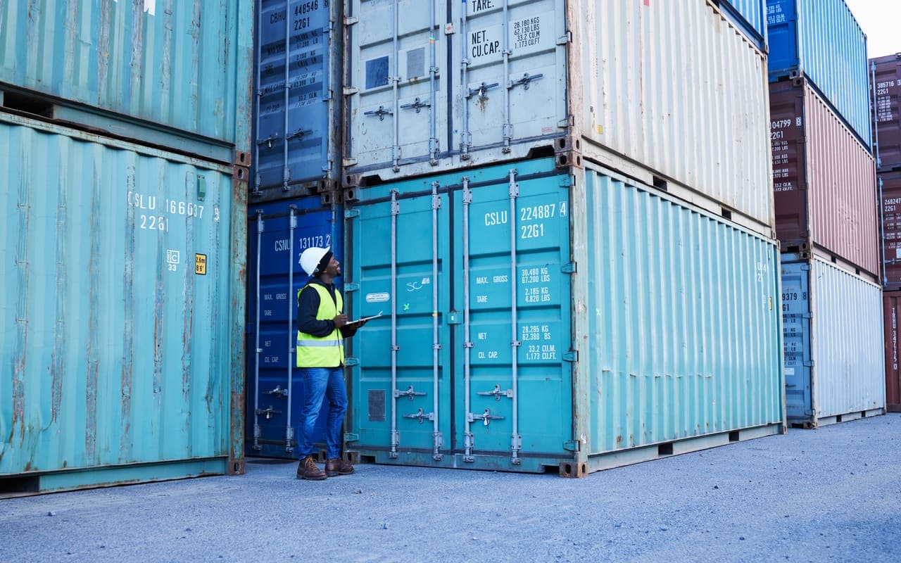 Medewerker met checklist controleert containers op een terrein